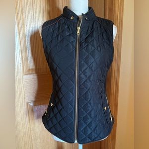 Black quilted vest with gold zippers and buttons